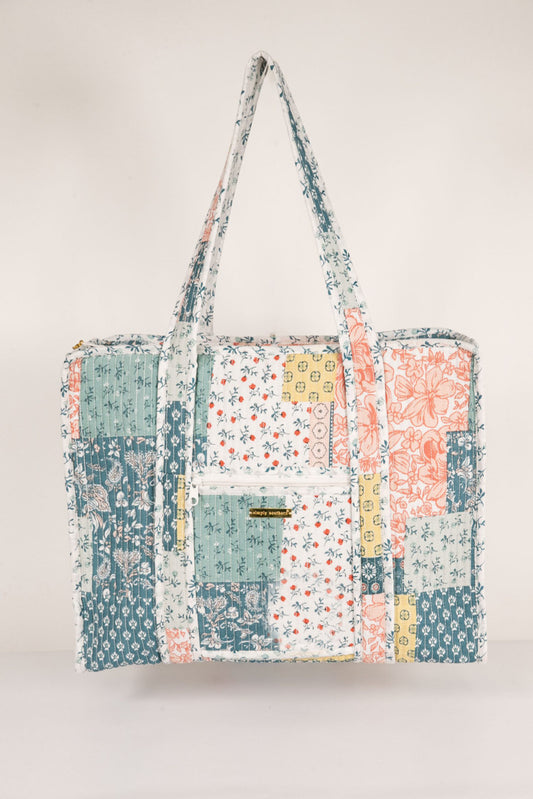 Patchwork tote bag with floral patterns on a light gray background