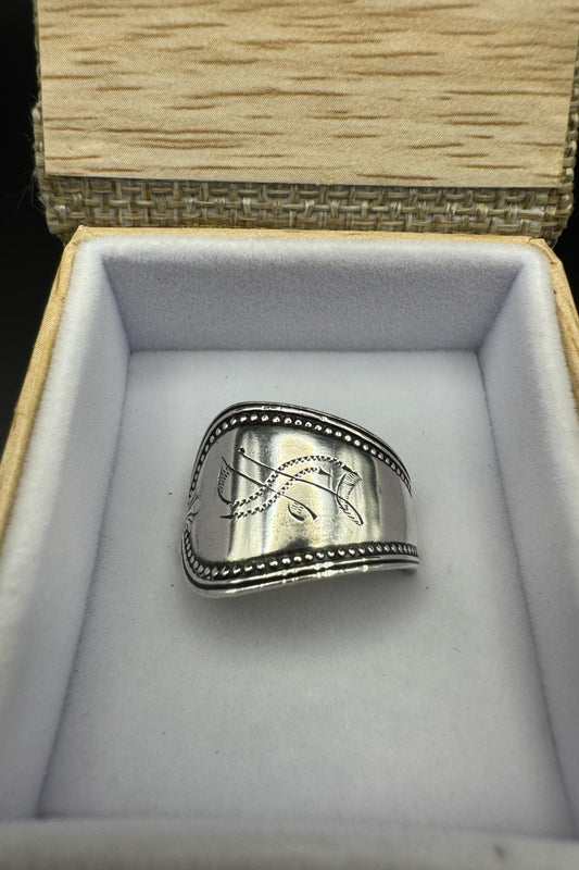 Silver ring with engraved design in a jewelry box