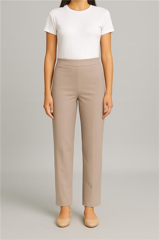 Person wearing beige pants and a white top on a plain background