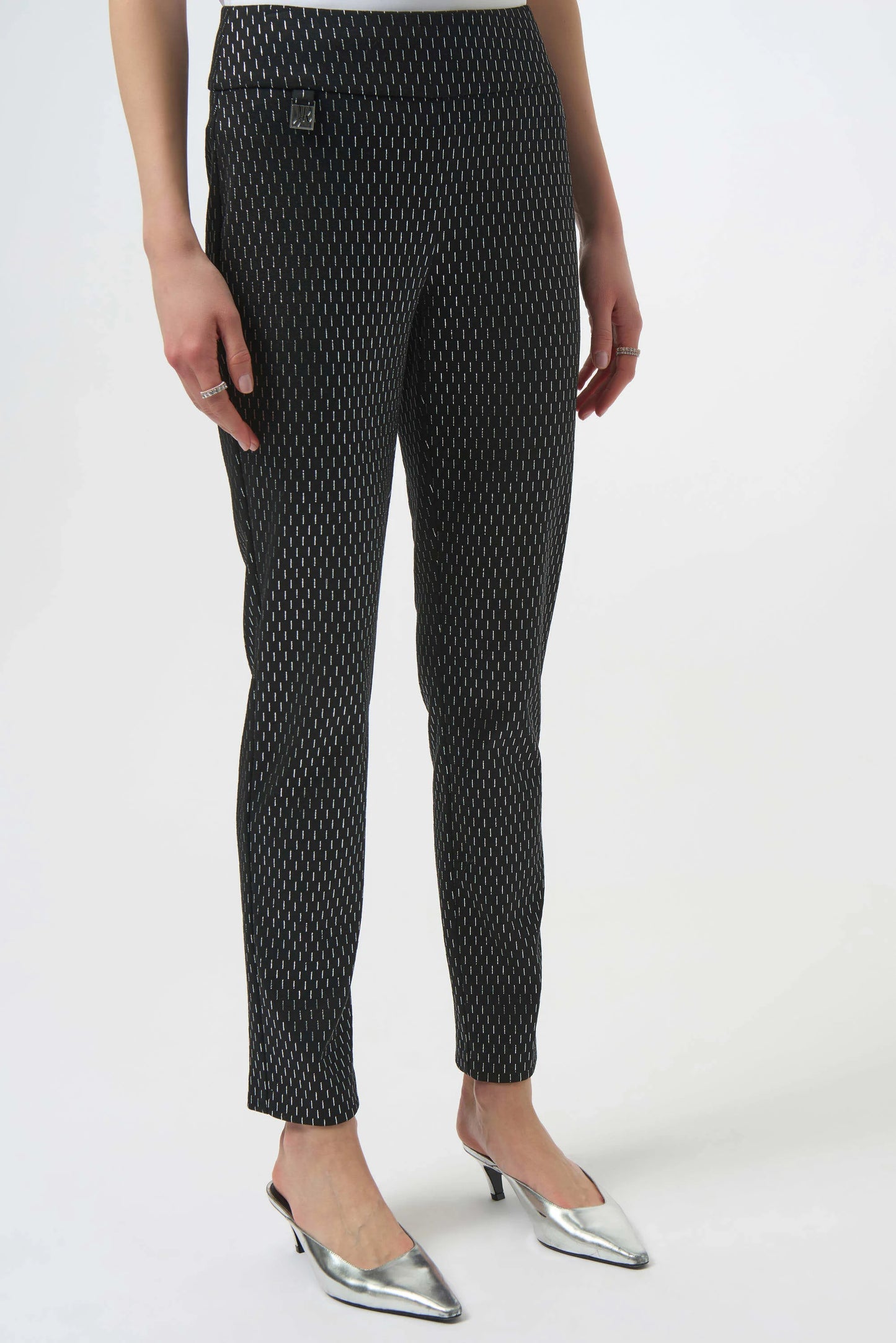 Black patterned pants worn by a person on a white background