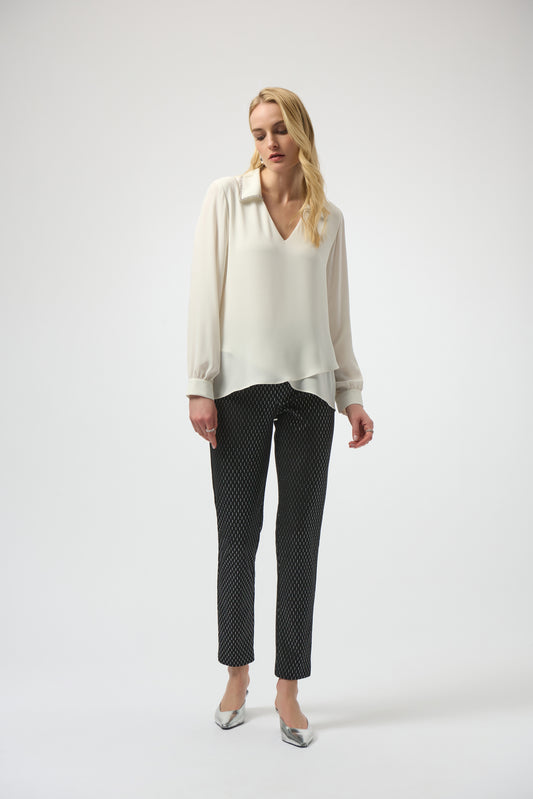 Woman wearing a white blouse and black patterned pants on a white background