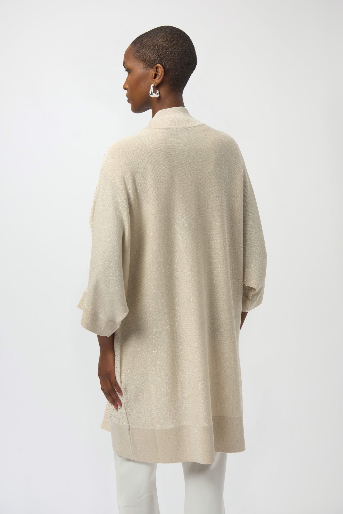 Woman wearing a beige kimono-style garment against a white background