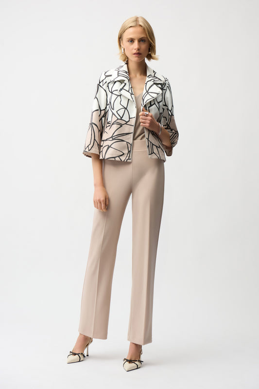 Woman wearing a patterned jacket and beige pants on a white background