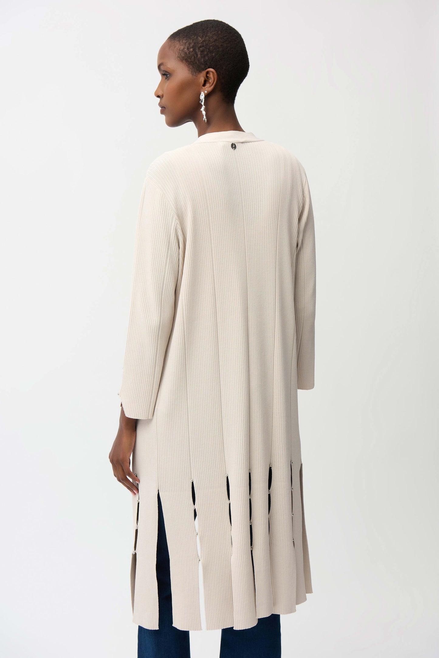 Woman wearing a long beige cardigan on a white background