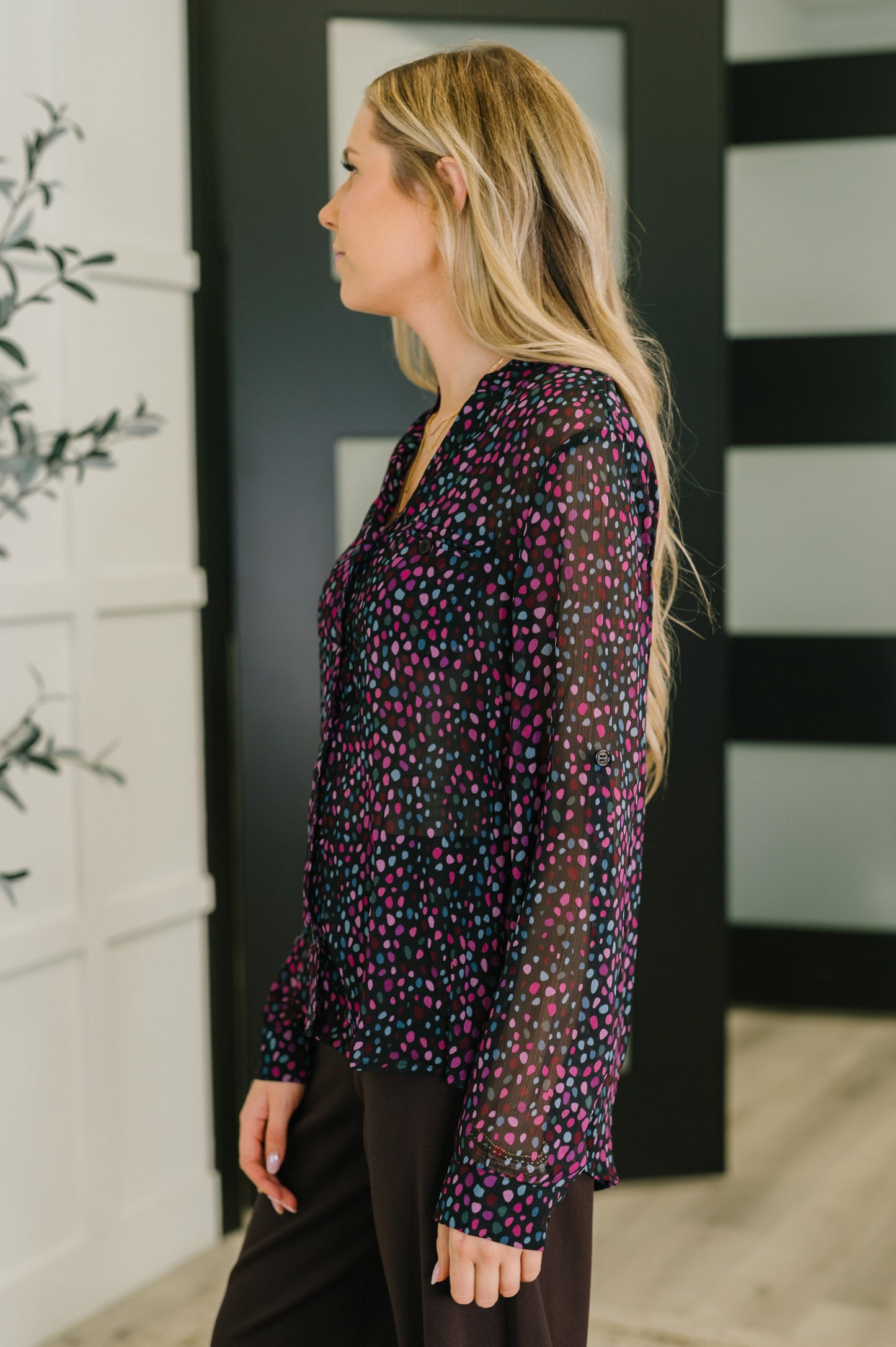 Woman wearing a dark floral blouse in an indoor setting