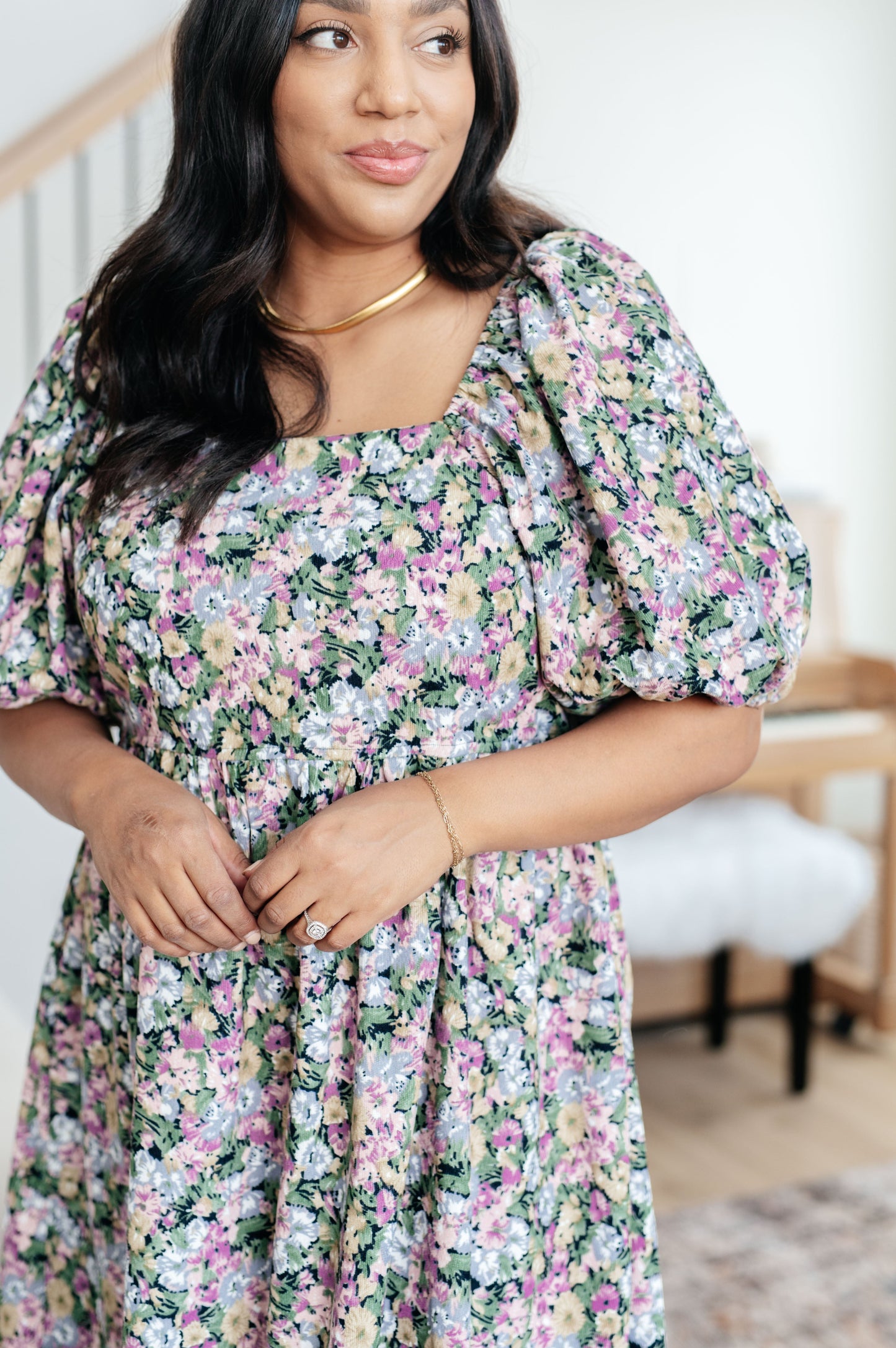 Woman wearing a floral dress in a home setting