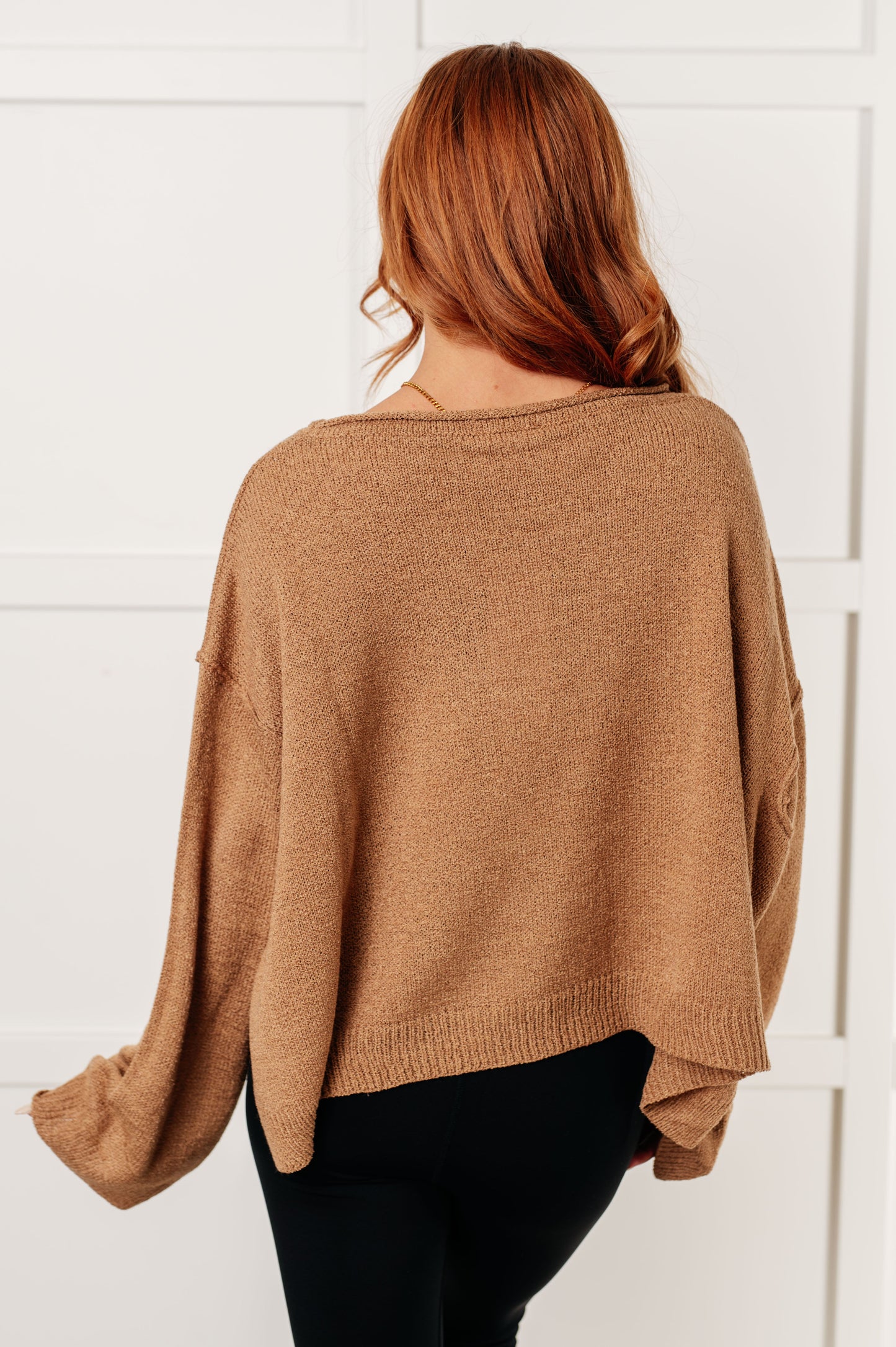 Woman wearing a brown sweater against a white background