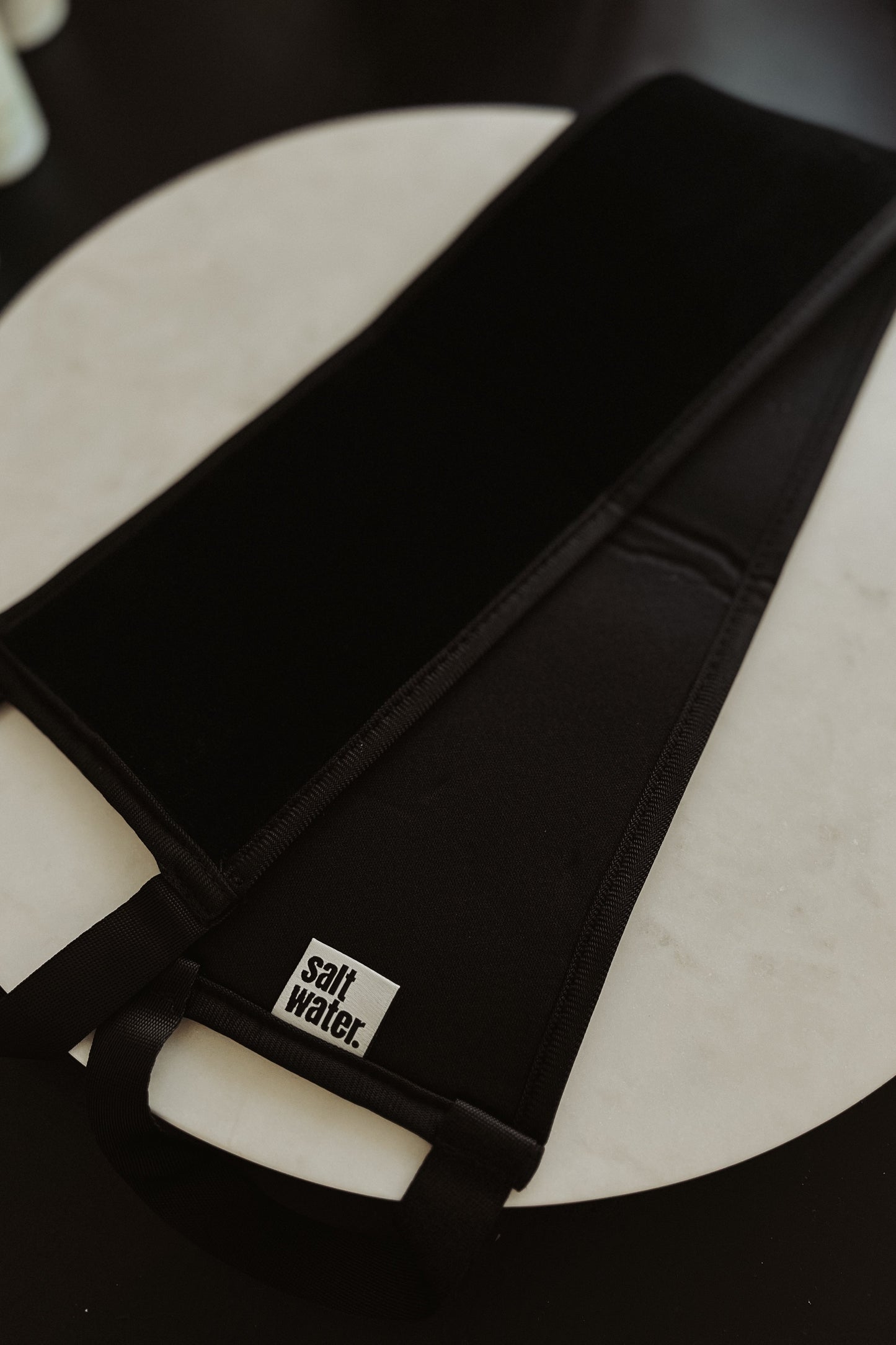 A black self-tan applicator designed for applying self-tan products to the back.