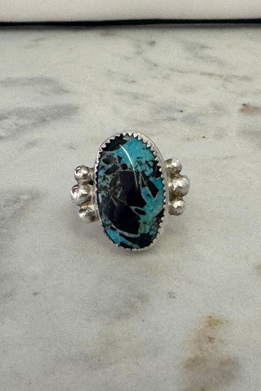 Ring with a blue gemstone on a marble surface