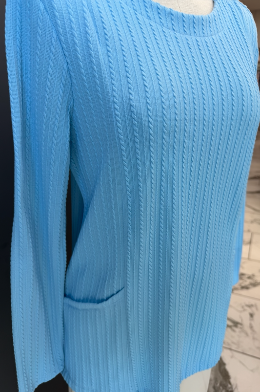 Light blue sweater on a mannequin with a blurred indoor background