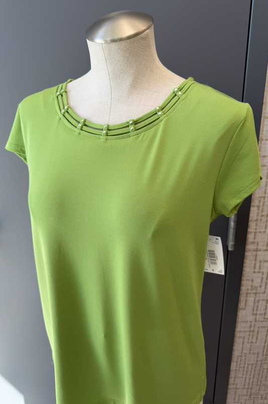 Green dress on a mannequin against a neutral background