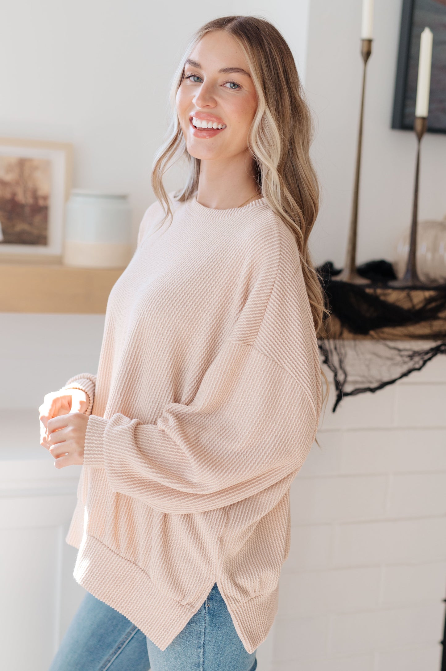 Woman wearing a beige sweater in a home setting