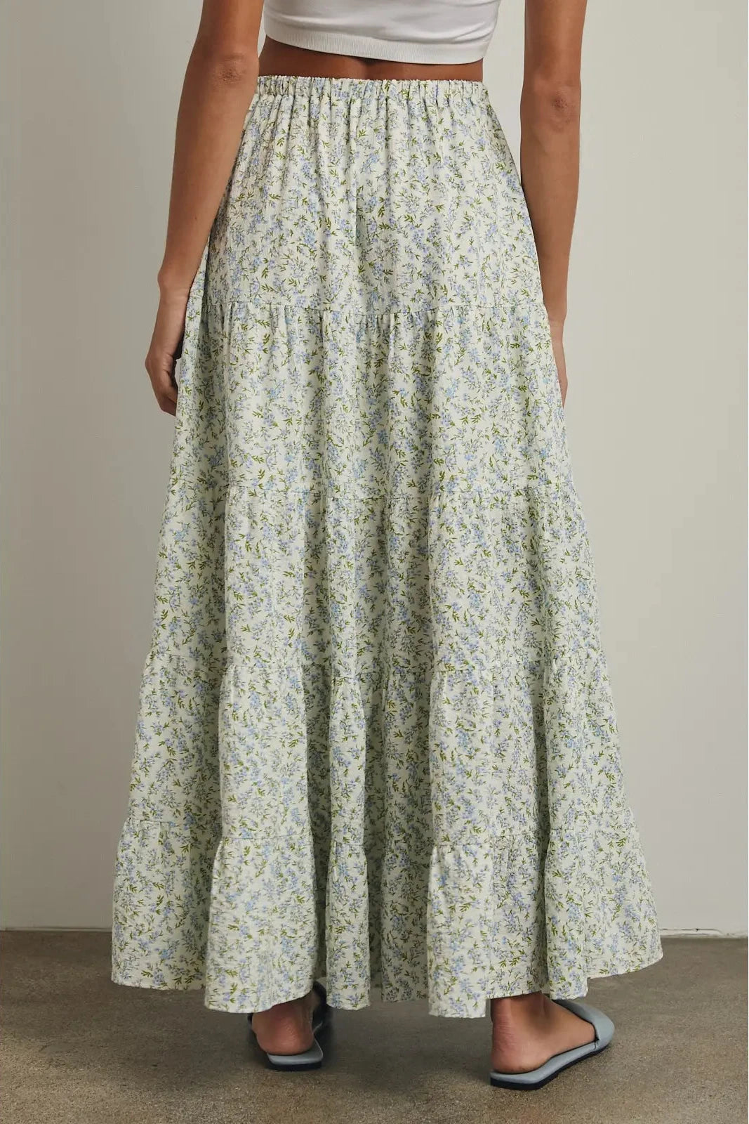 Long floral skirt worn by a person on a neutral background