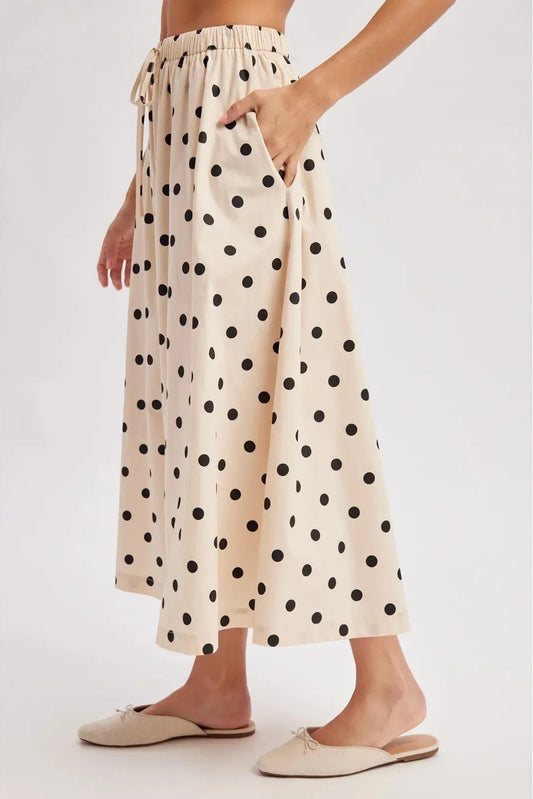 Person wearing a polka dot skirt on a white background