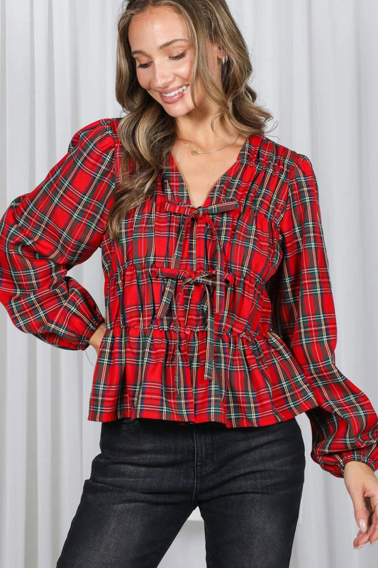 Woman wearing a red plaid blouse with a white background