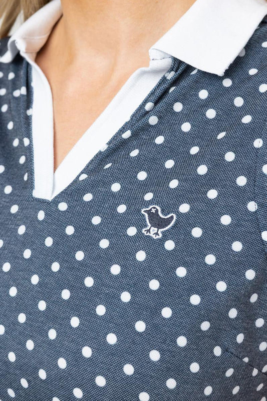 Navy sleeveless top with white polka dots and a small logo on a white background