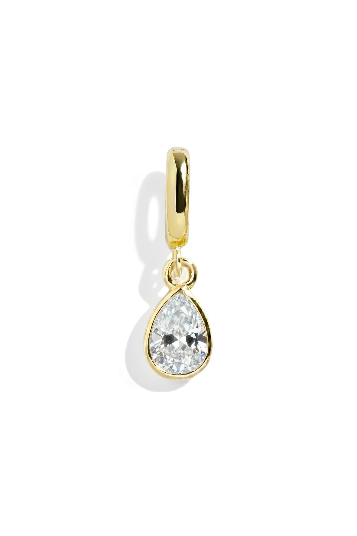 Gold teardrop-shaped earring with clear gemstone on a white background