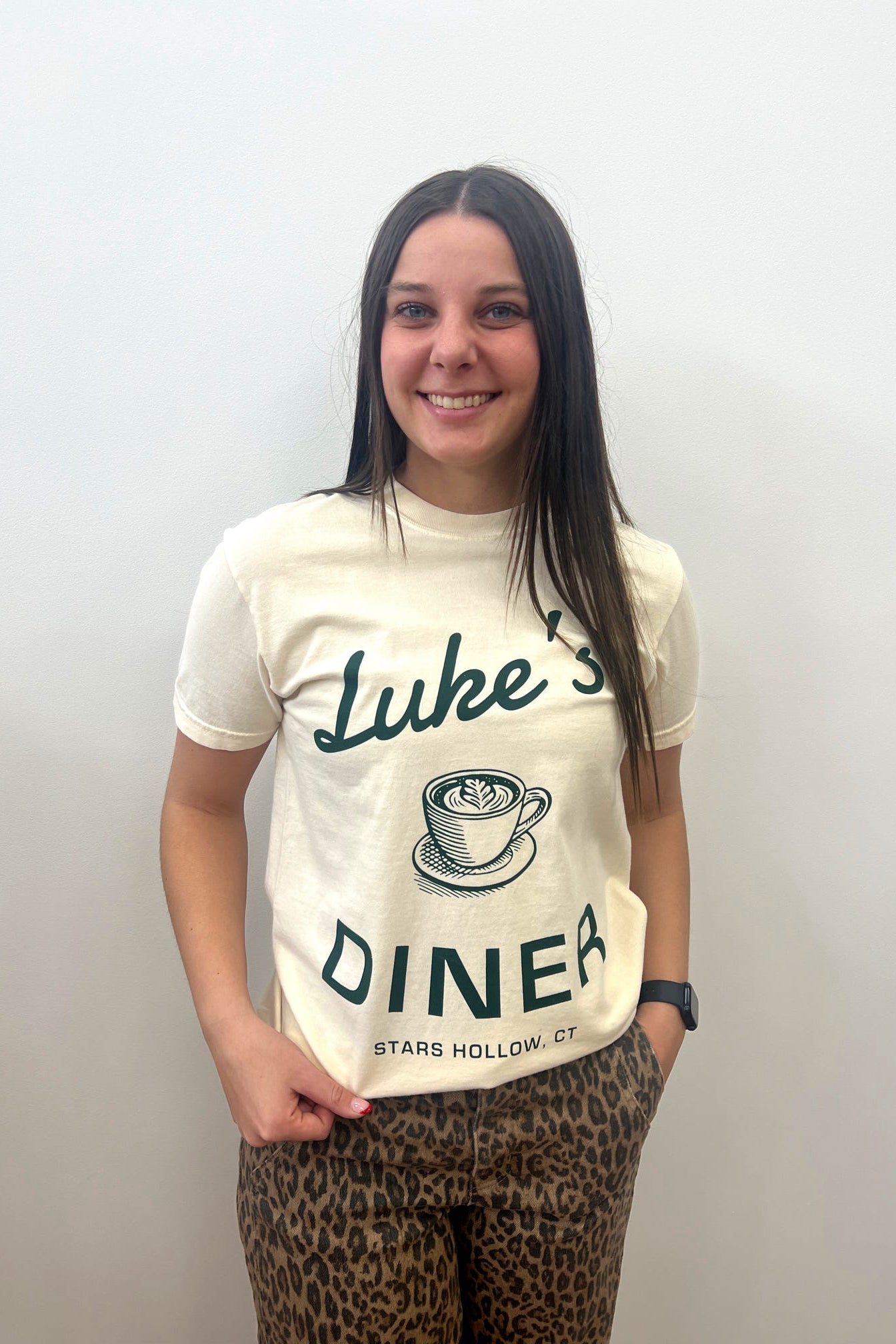 Person wearing a 'Luke's Diner' t-shirt with a plain background