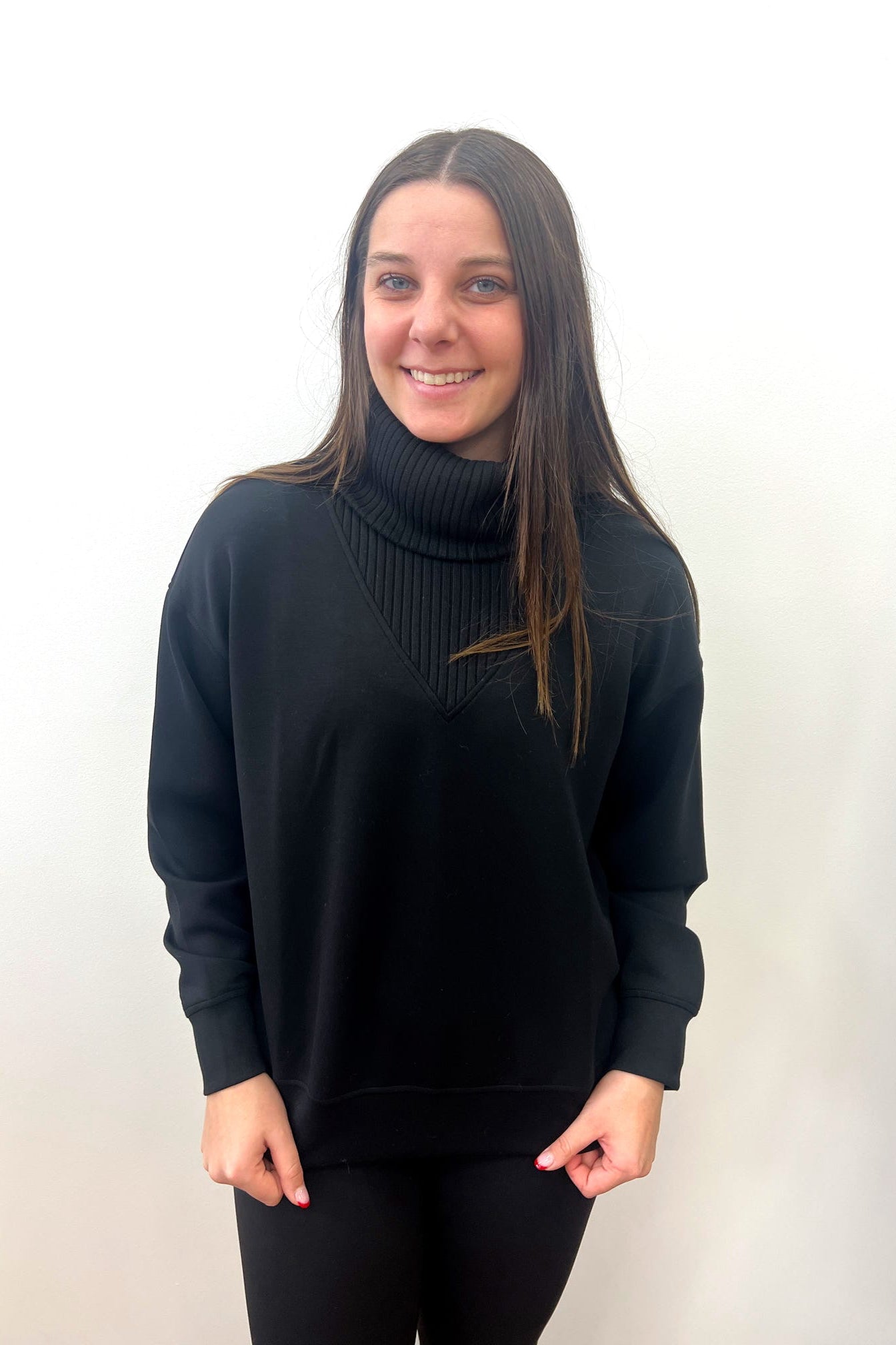 Person wearing a black turtleneck sweater against a white background