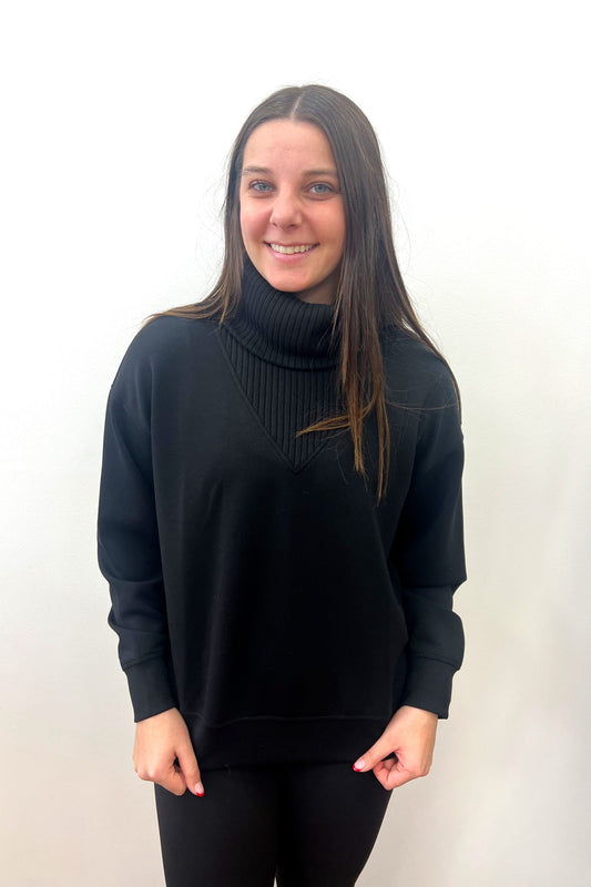 Person wearing a black turtleneck sweater against a white background