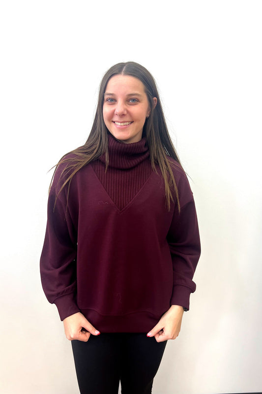 Woman wearing a maroon sweater against a white background