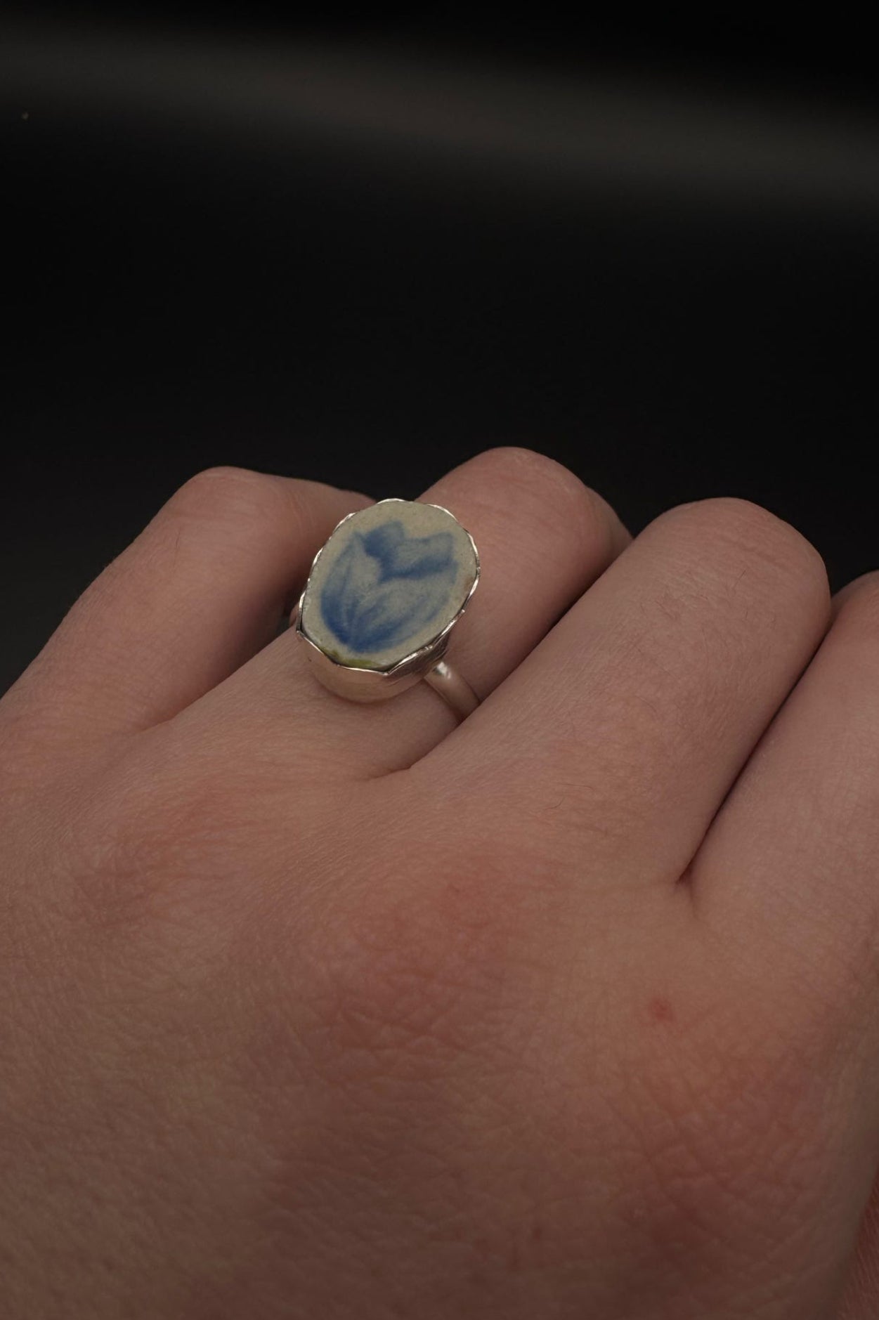 Blue tulip design on ring set in sterling silver; displayed on hand