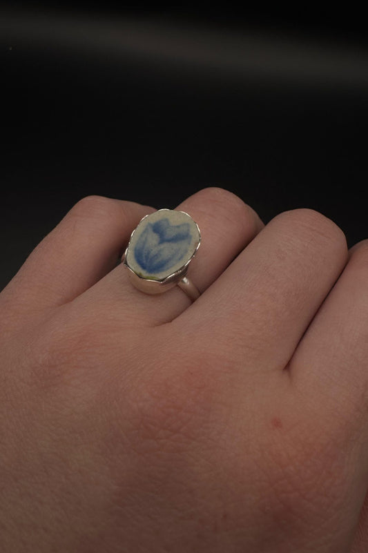 Blue tulip design on ring set in sterling silver; displayed on hand