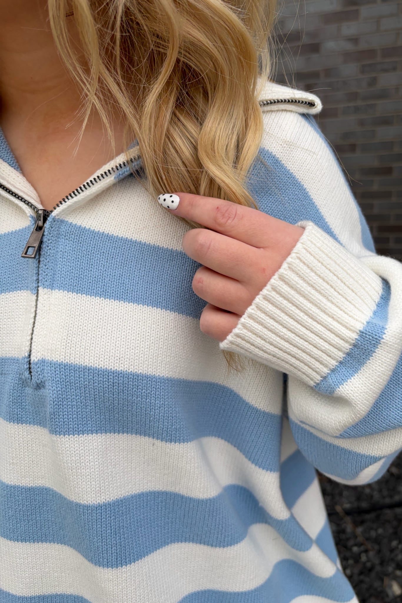 Person wearing a blue and white striped sweater with a blurred background