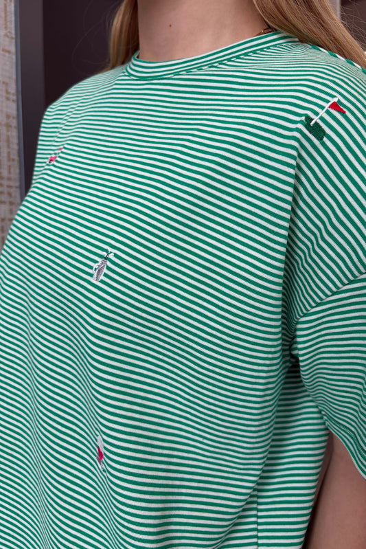 Green and white striped shirt with embroidered logos on a person wearing it.