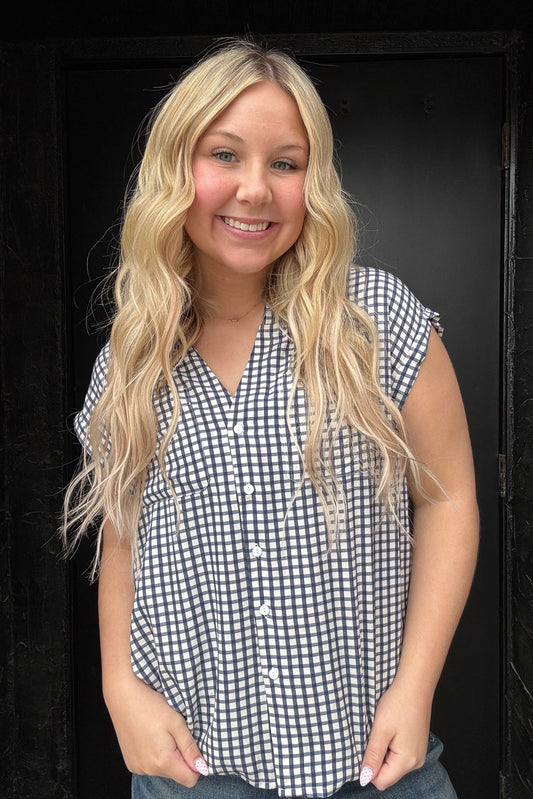 Woman wearing a black and white checkered shirt against a black background
