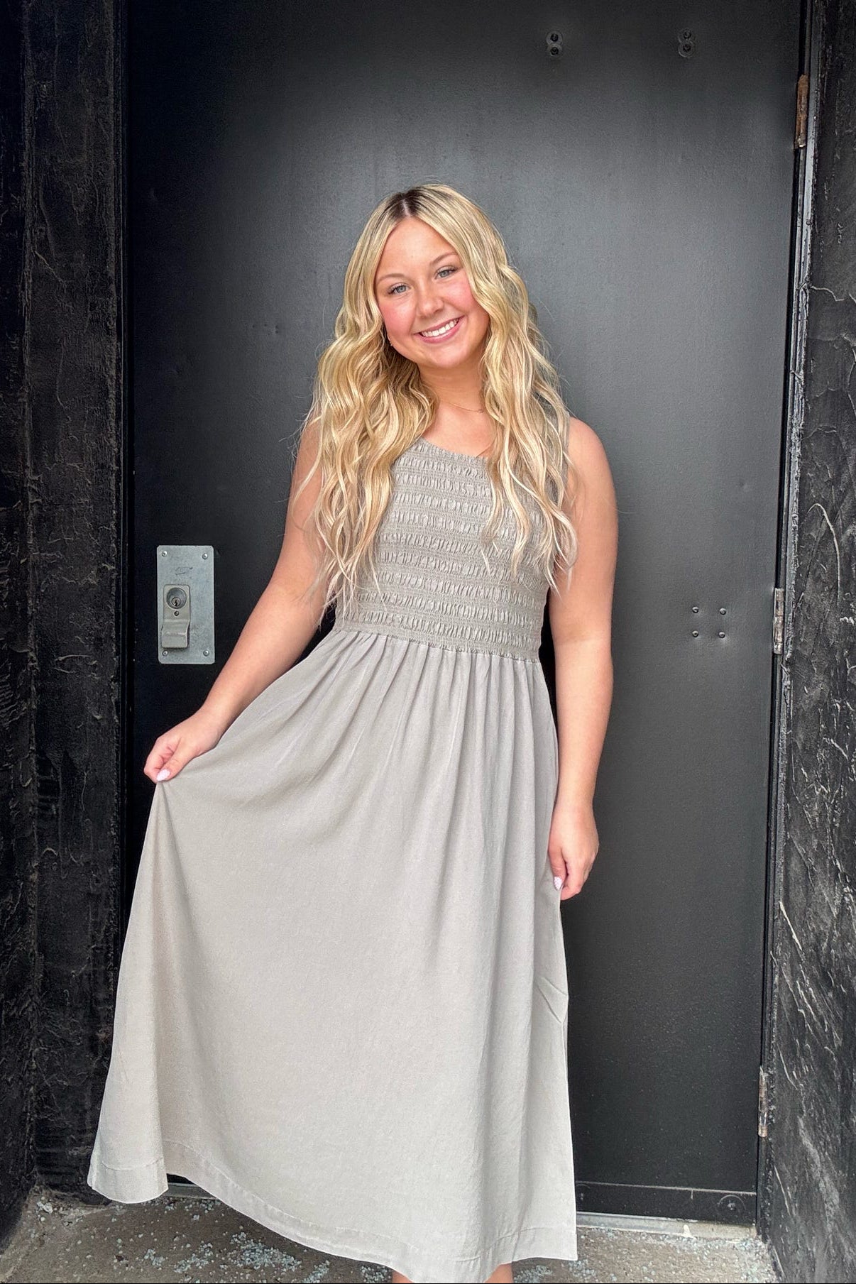 Woman in a gray dress standing in a dark doorway