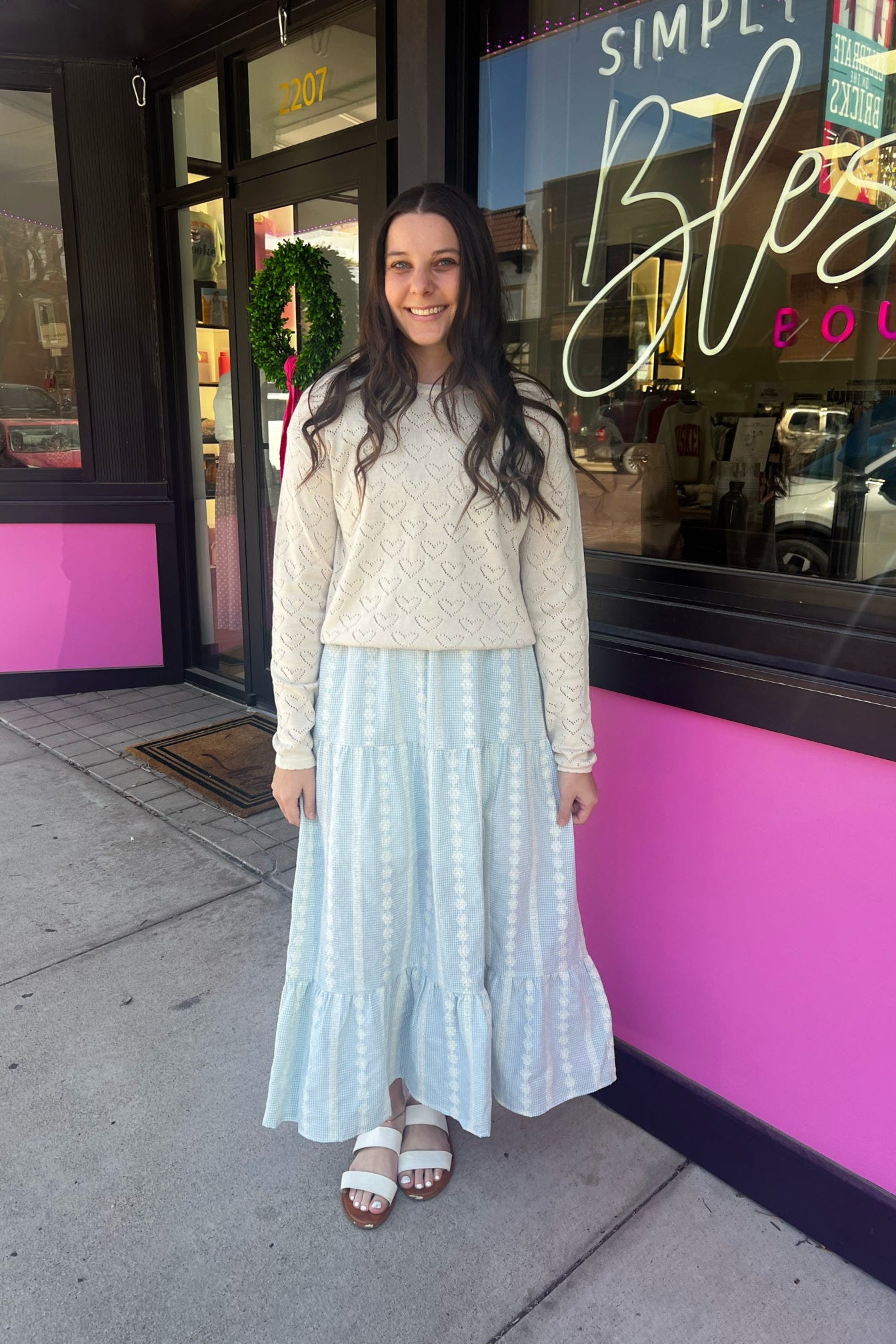 Woman standing outside a store with a pink and black exterior