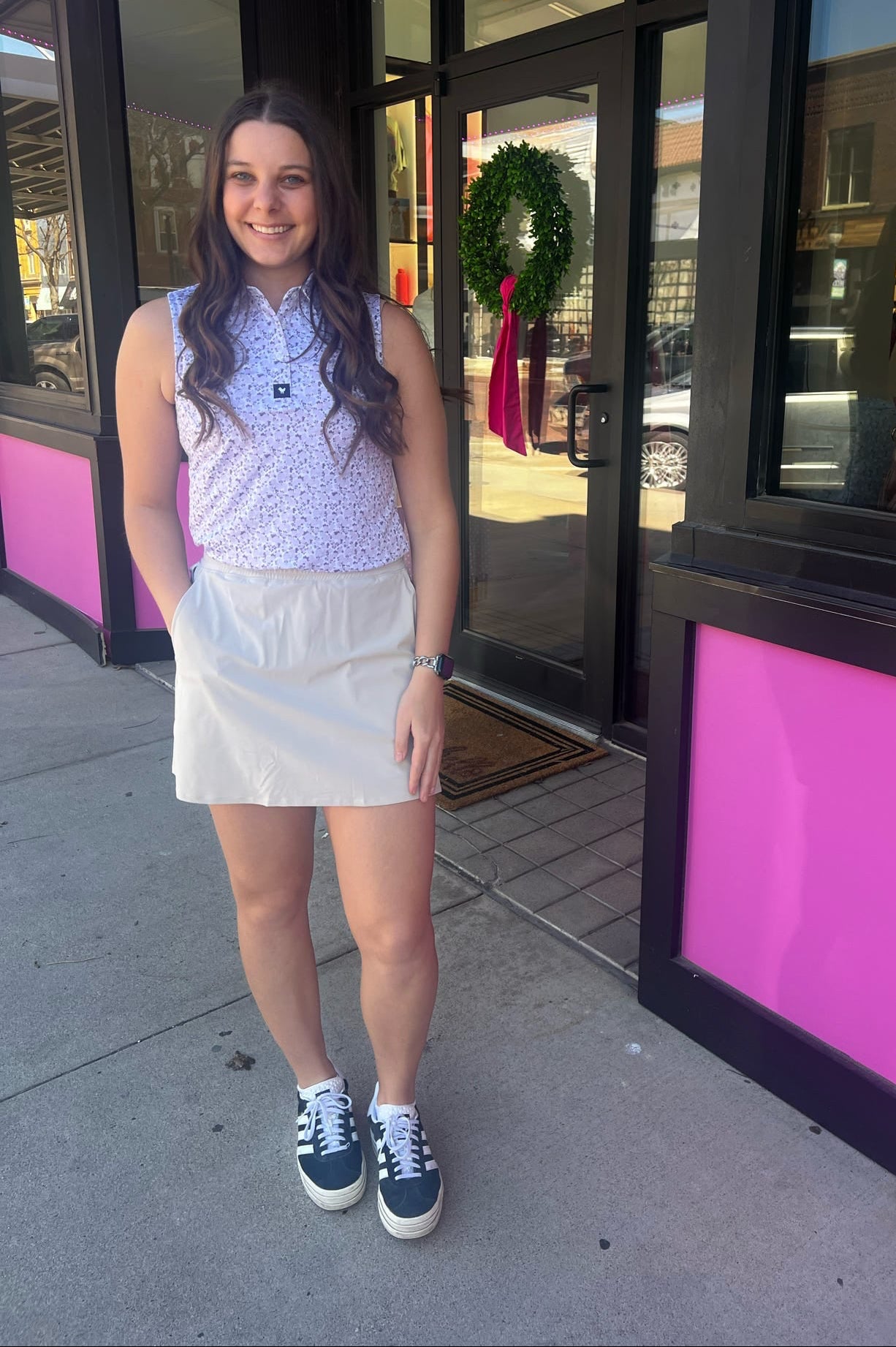 Woman standing outside a store with pink and black exterior