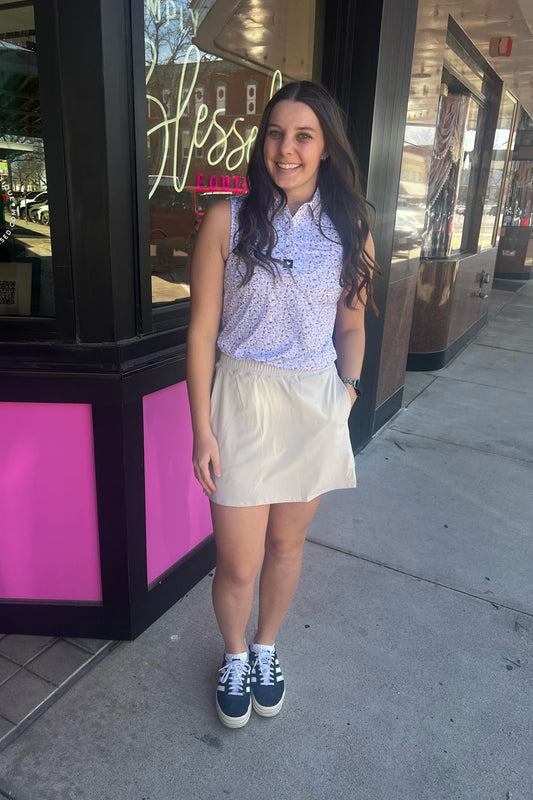 Woman standing on a sidewalk in front of a store with a pink display case.