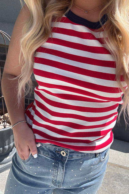 Person wearing a red and white striped shirt with blue jeans outdoors.