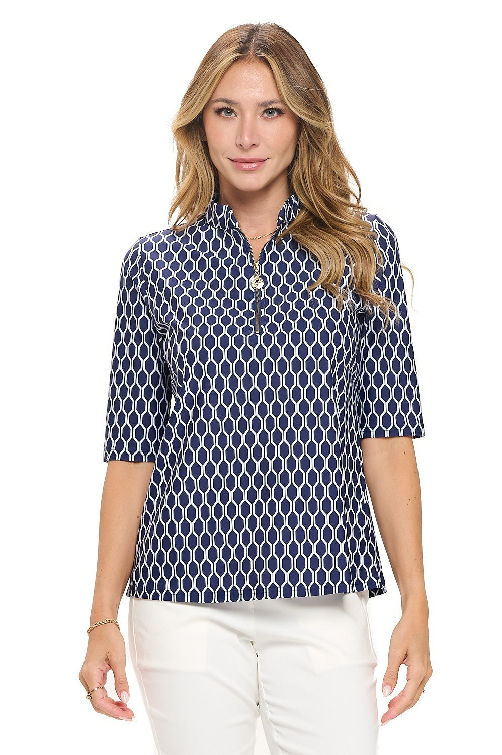 Woman wearing a navy blue patterned shirt with white pants on a white background