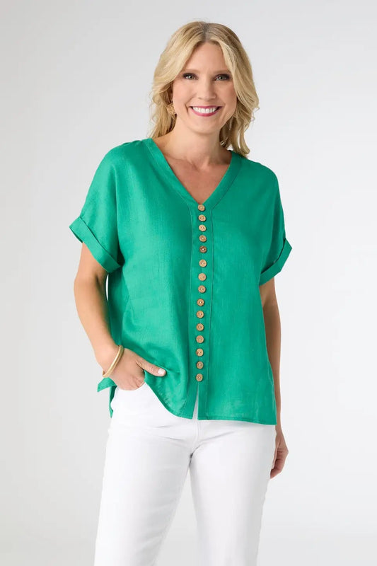 Woman wearing a green blouse with wooden buttons on a white background
