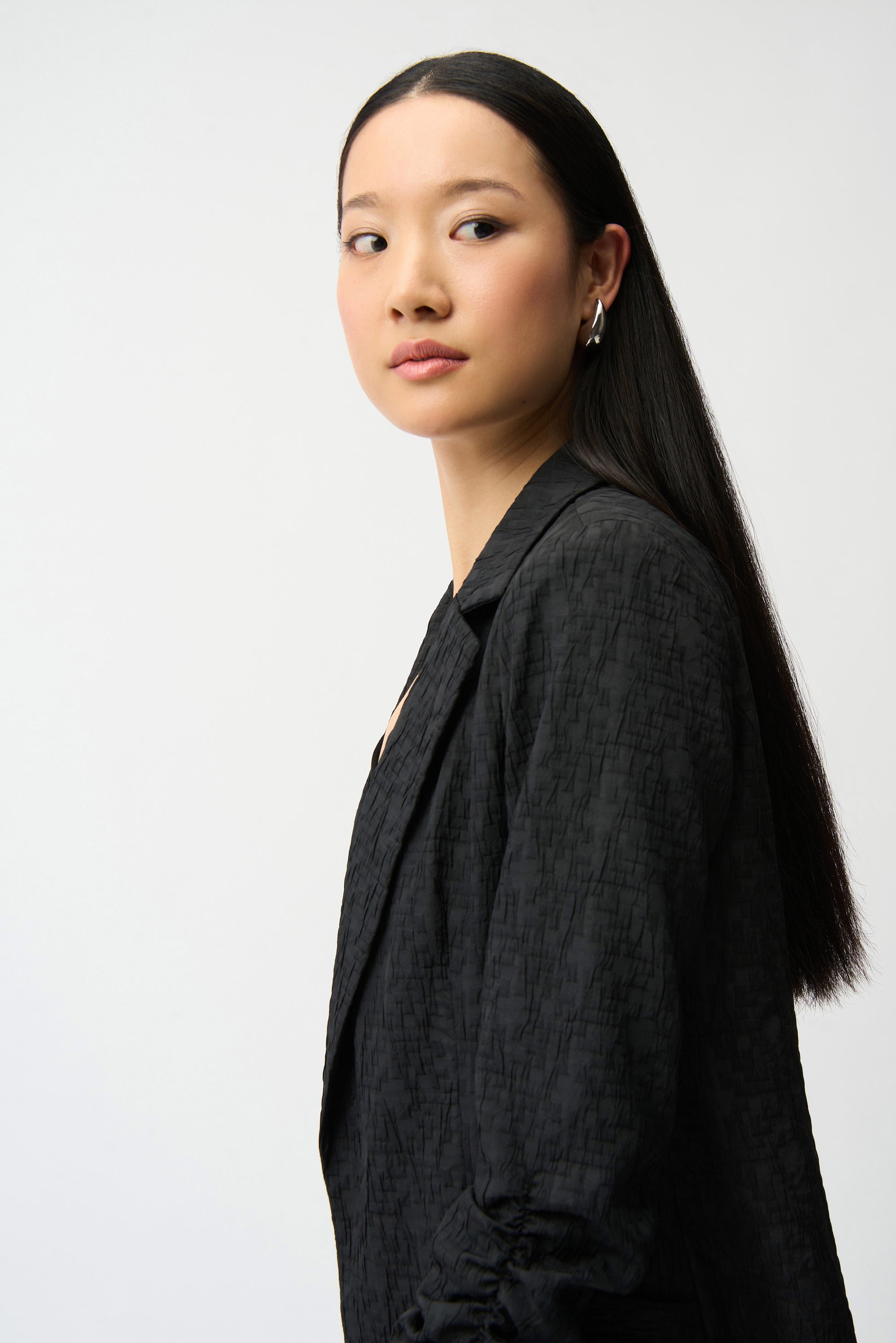 Woman wearing a black blazer against a white background