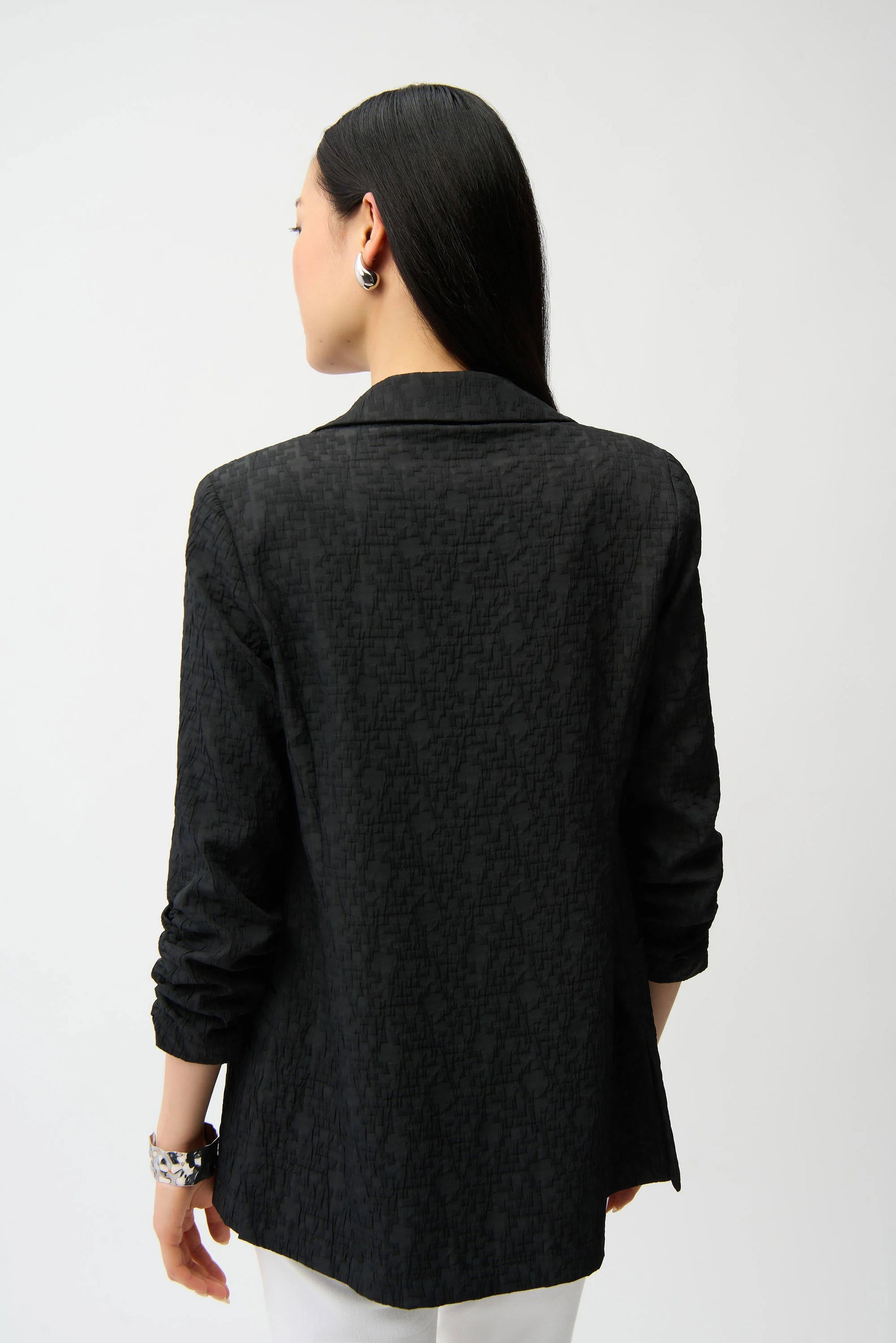 Person wearing a black blazer from behind on a white background