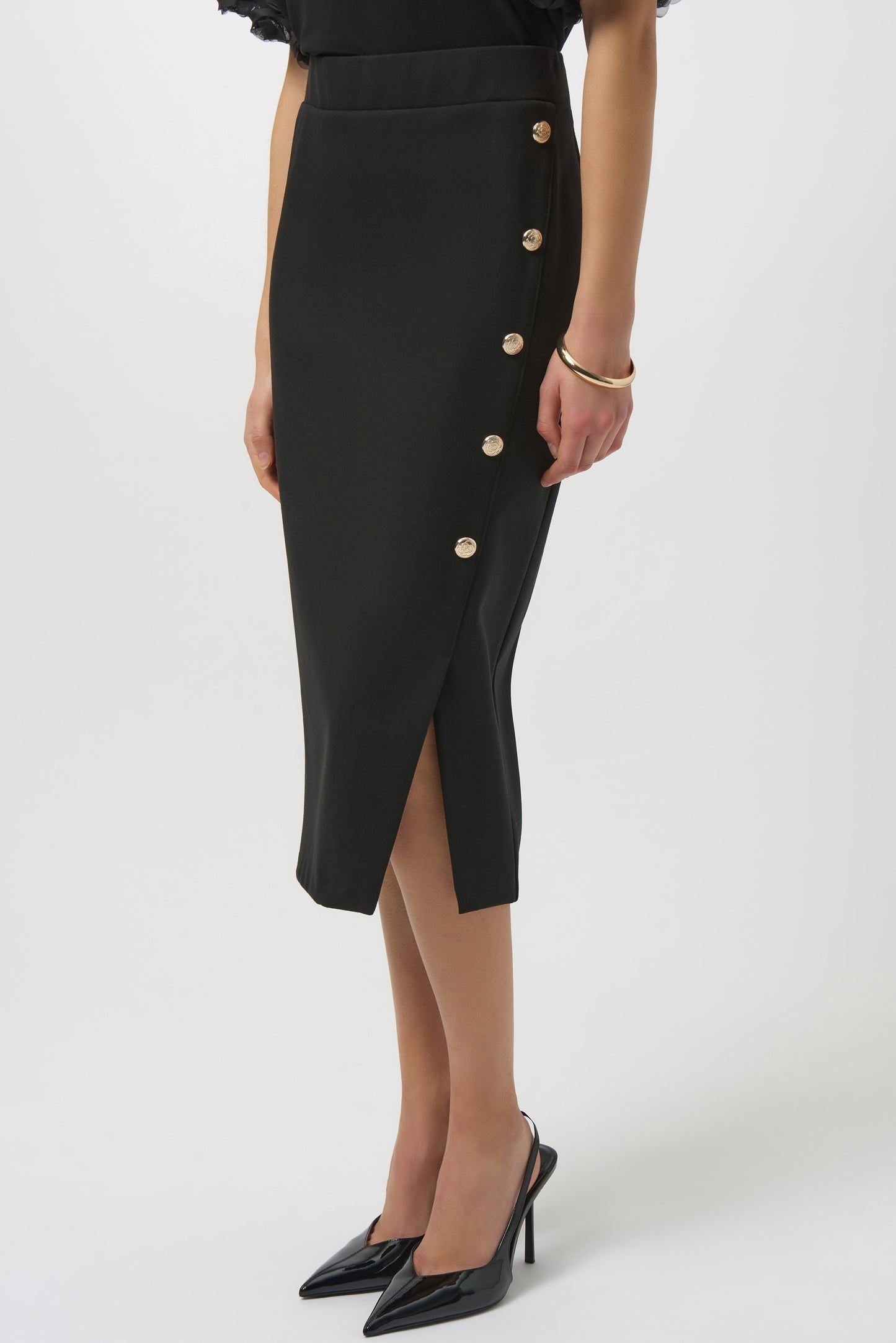 Black buttoned skirt worn by a person on a white background
