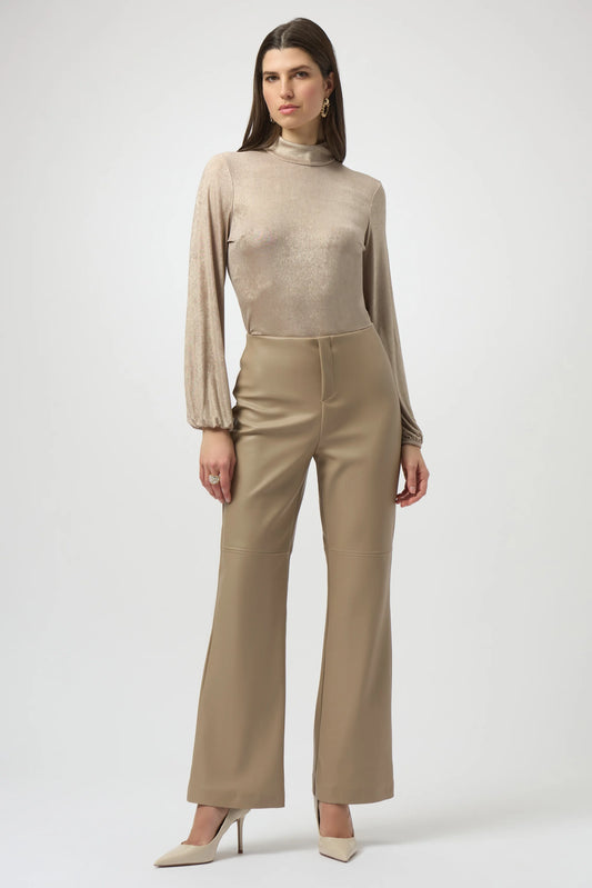 Woman wearing a beige long-sleeve top and high-waisted pants on a white background