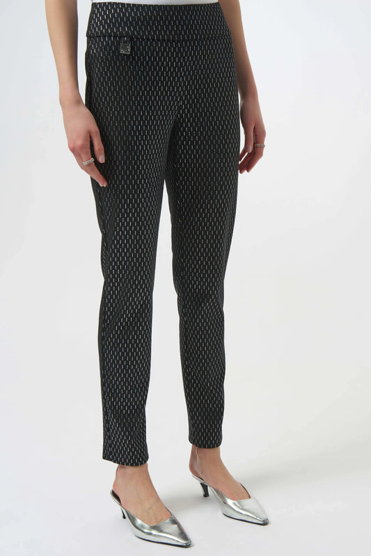 Black patterned pants worn by a person on a white background