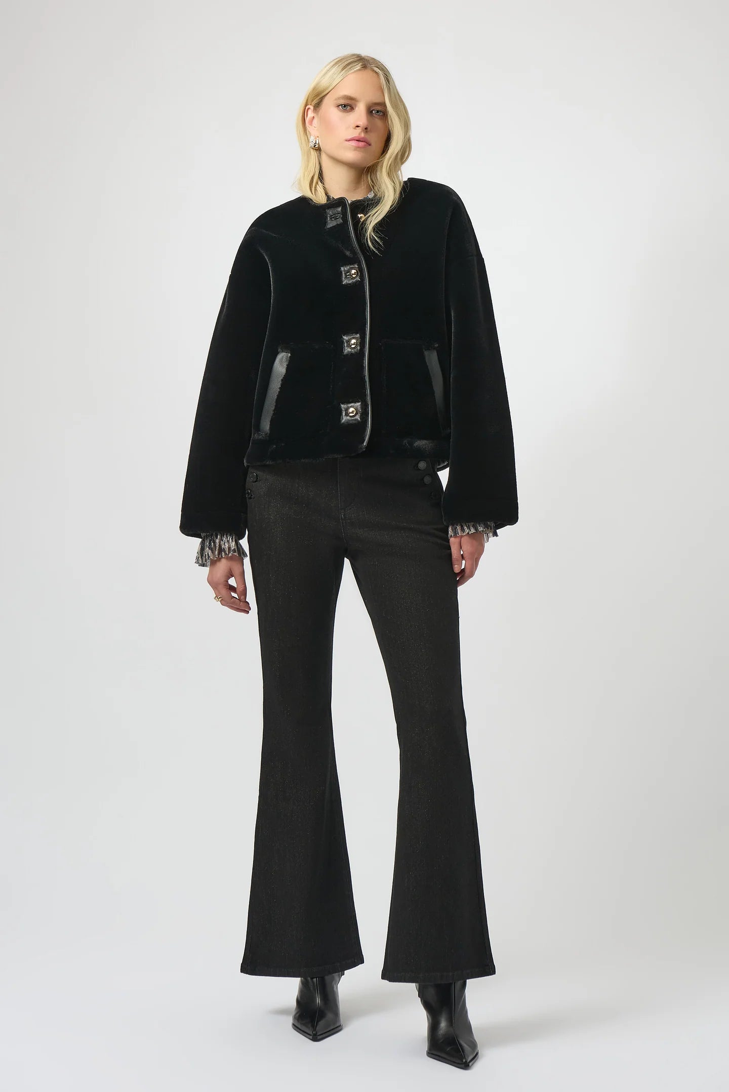 Woman wearing a black coat and pants on a white background