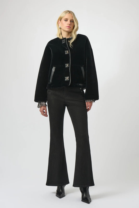 Woman wearing a black coat and pants on a white background