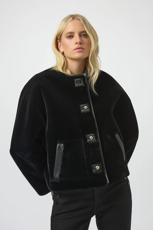 Woman wearing a black jacket with button details on a white background