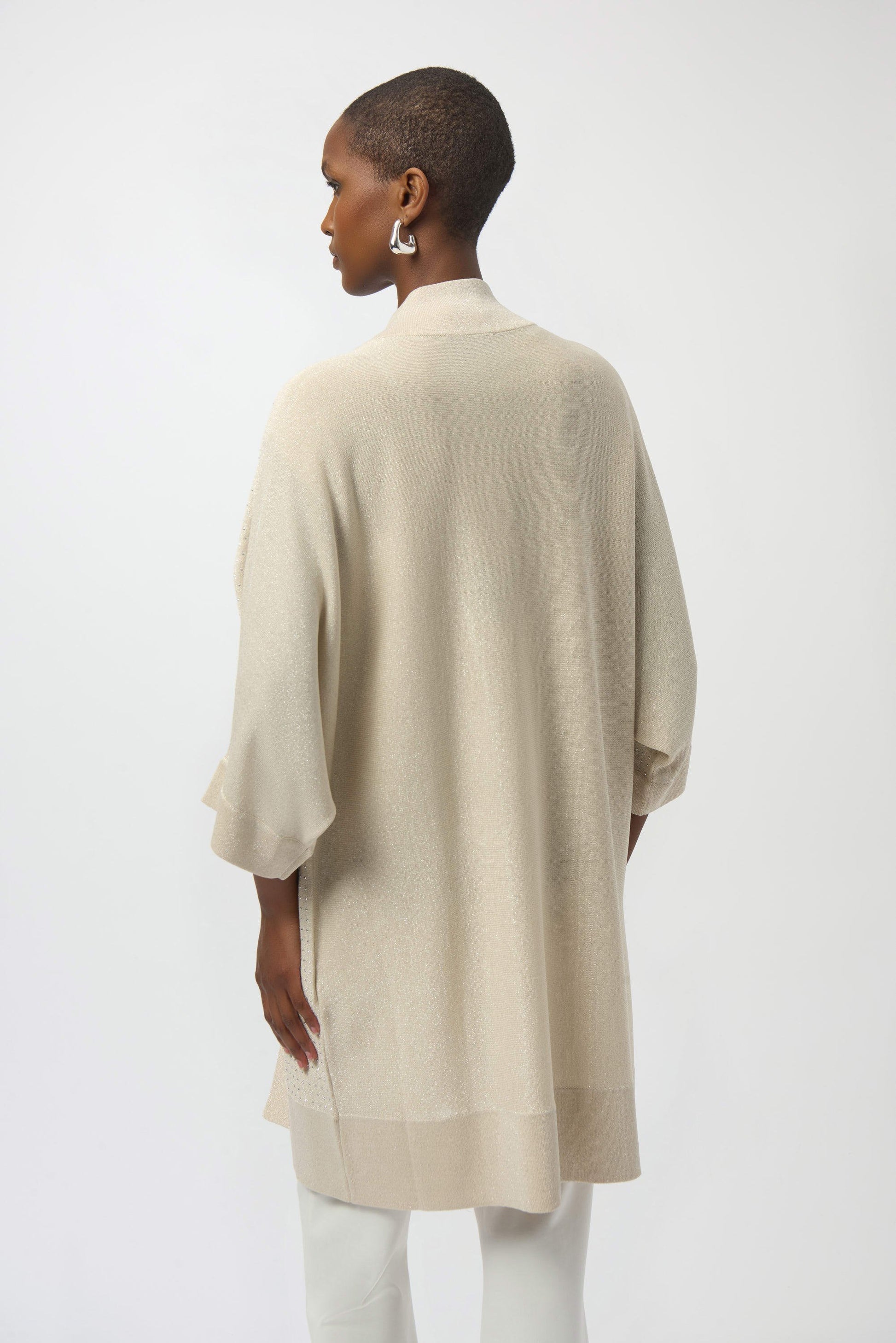 Woman wearing a beige kimono-style garment against a white background