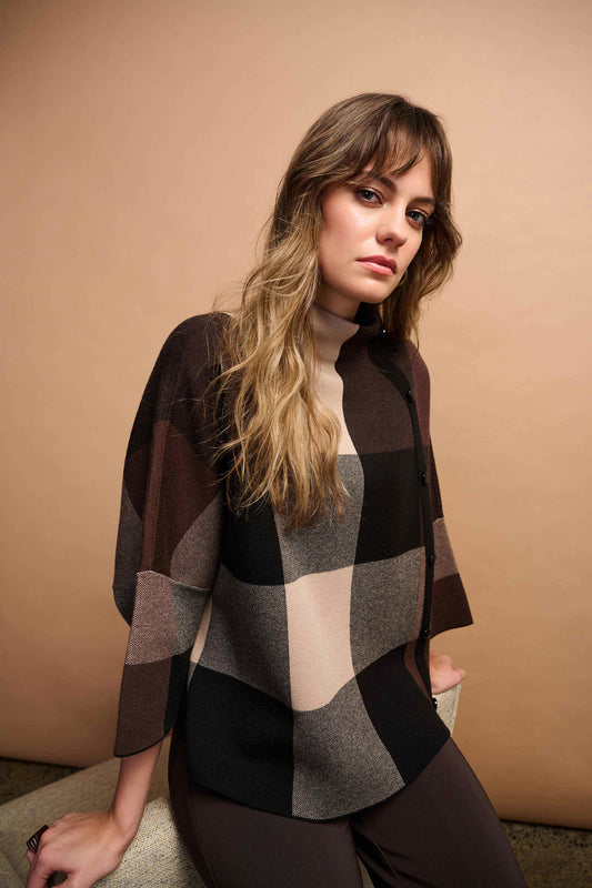 Woman wearing a checkered sweater against a beige background