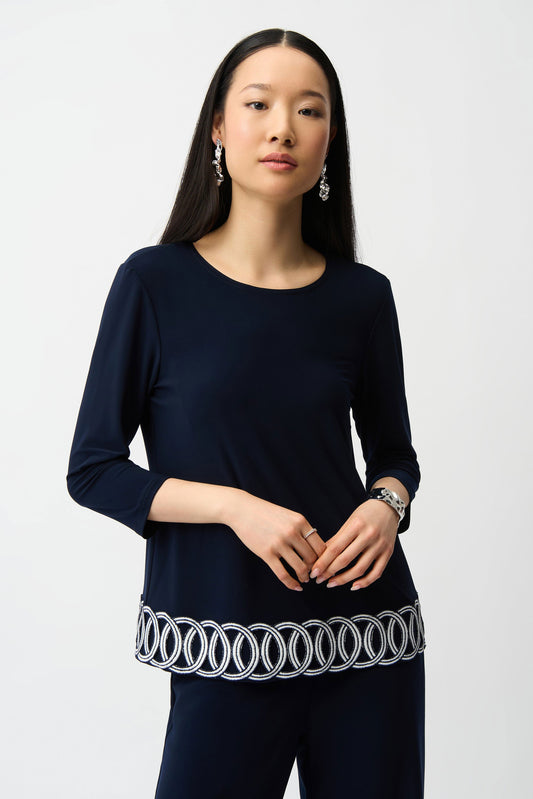 Woman wearing a navy blue outfit with a white detail on a white background