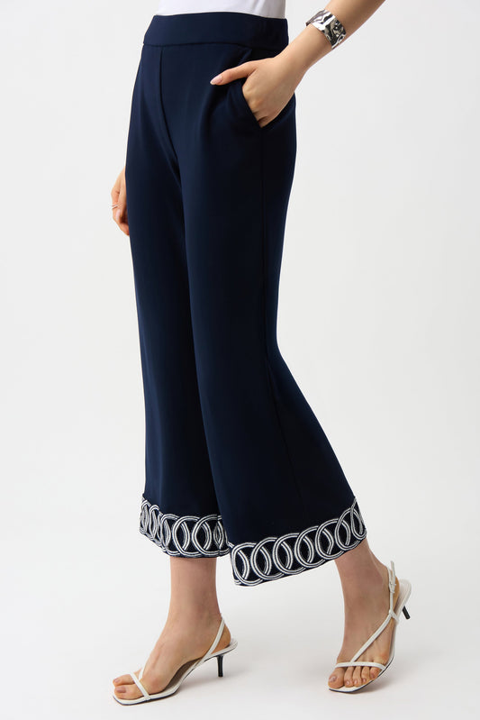 Navy blue pants with decorative hem on a white background