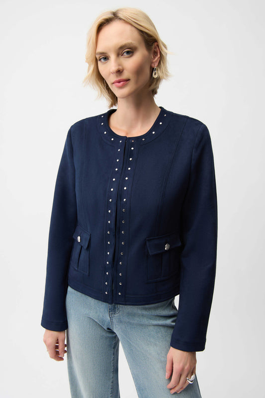 Woman wearing a navy blue jacket with pearl embellishments on a white background